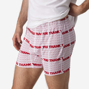 Close up side view of man wearing red & white printed "thank you" slim fit boxers & white t-shirt.