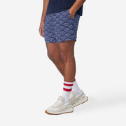 Side view of man wearing blue lounge shorts with sunrise pattern.