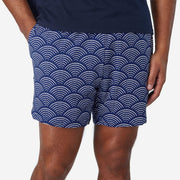 Close up of man wearing blue lounge shorts with sunrise pattern.