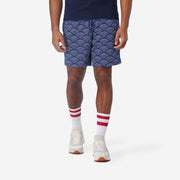 Front view of man wearing blue lounge shorts with sunrise pattern.