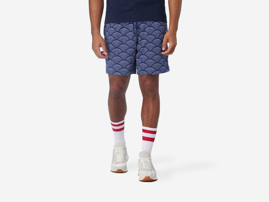 Front view of man wearing blue lounge shorts with sunrise pattern.