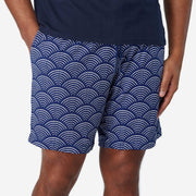 Front view of man wearing blue lounge shorts with sunrise pattern.