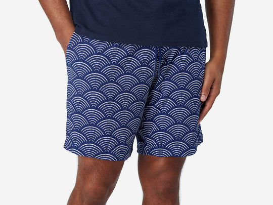 Front view of man wearing blue lounge shorts with sunrise pattern.