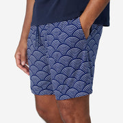 Close up of man wearing blue lounge shorts with sunrise pattern.