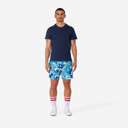 Full body front view of man wearing blue and white wave printed lounge shorts.