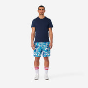 Full body front view of man wearing blue and white wave printed lounge shorts.