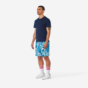 Full body side view of man wearing blue and white wave printed lounge shorts.