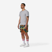 Fully body side view of man wearing green lounge shorts with tiger and snake print.