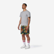 Full body side view of man wearing green lounge shorts with tiger and snake print.