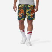 Front view of man wearing green lounge shorts with tiger and snake print.